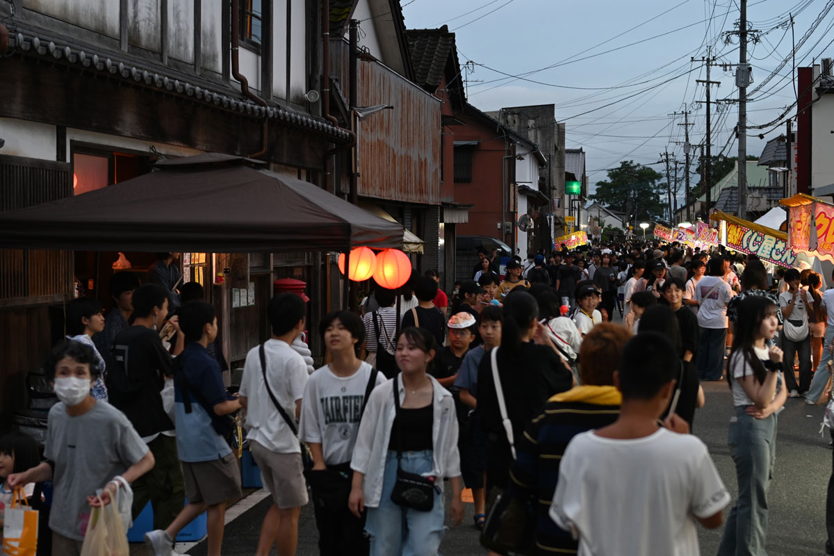 商店街の夏祭りで、「風の館塩屋」の前の道が屋台や人で賑わっている様子